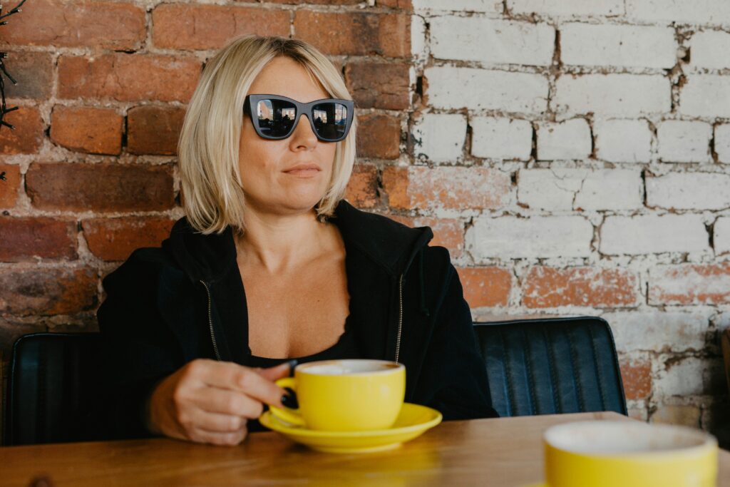 Woman sitting with coffee reflecting on hormone therapy for perimenopause decisions.