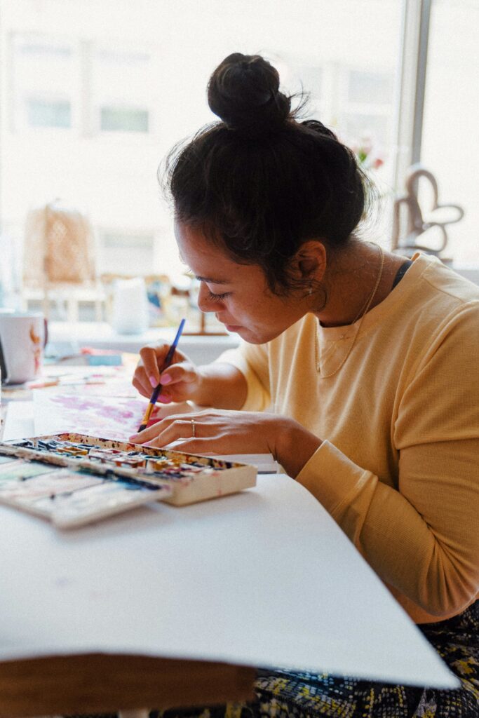 Woman painting with focus and joy, representing rediscovering creativity and purpose in her 40s.