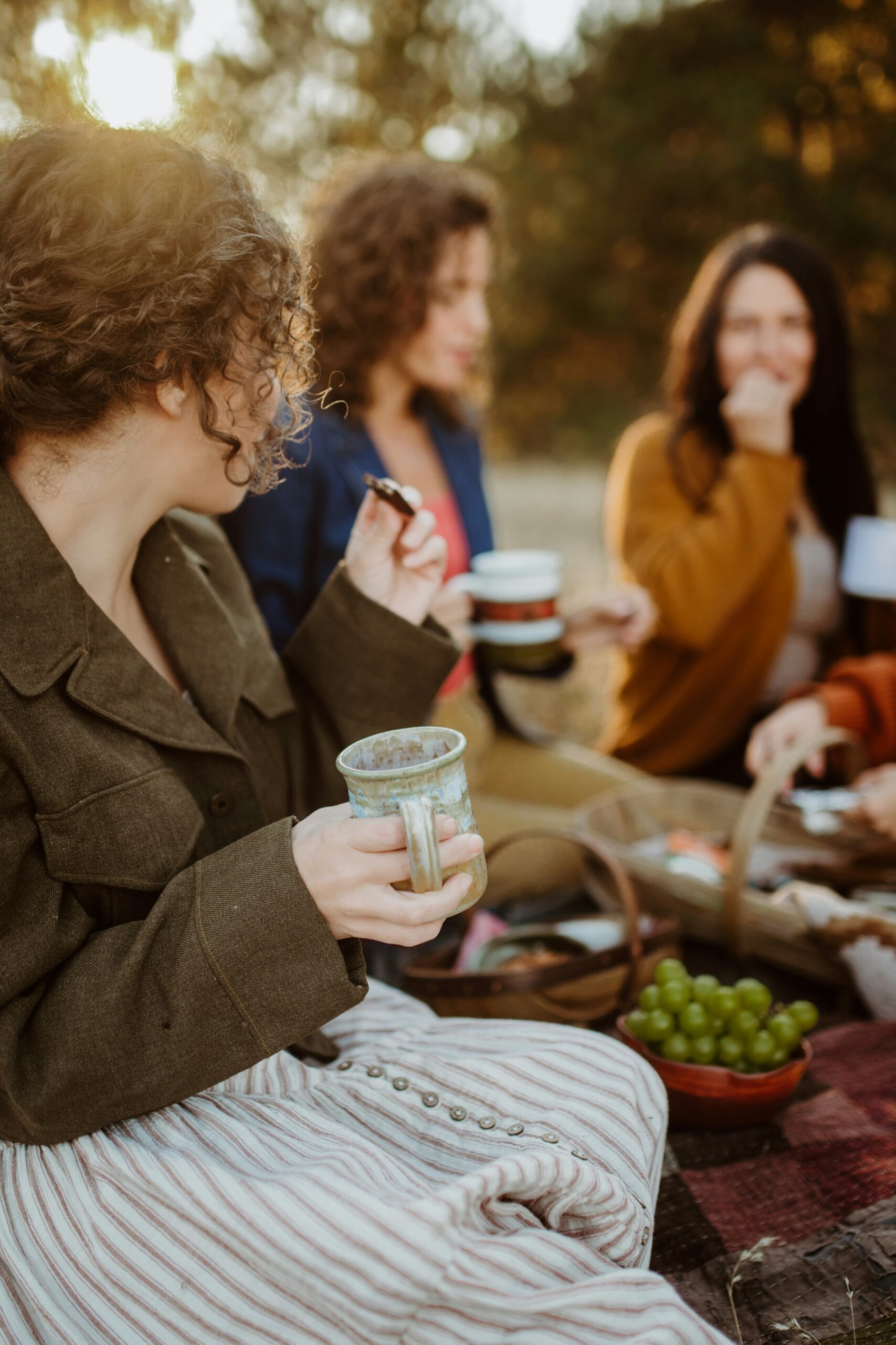 Women sitting together outdoors sharing coffee and conversation to strengthen their relationships
